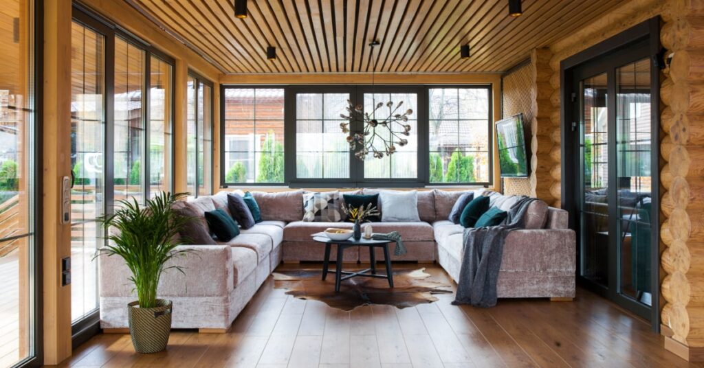 veranda en bois avec lambris au plafond donnant un côté rustique au salon familial