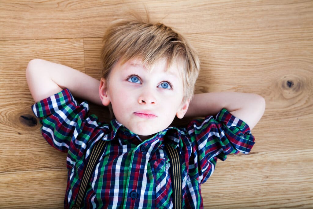 Enfant couché sur du parquet