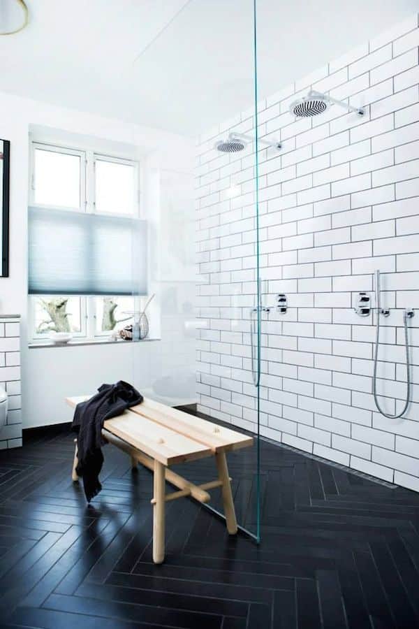 Contraste sol noir et murs blancs dans une douche à l'italienne