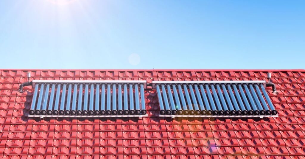 chauffe eau solaire sur le toit d'une maison avec tuiles rouges
