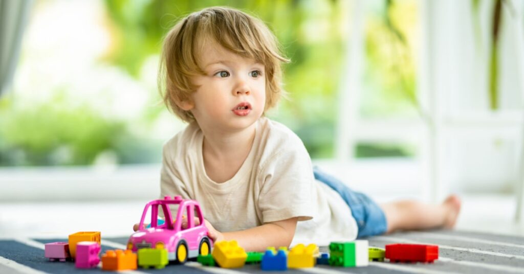 mignon petit garçon jouant à des jeux dans une véranda aménagé en salle de jeux