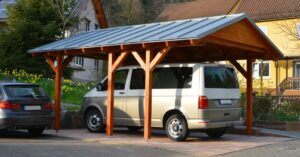 carport en bois avec toit en tole protégeant une camionnette devant une maison
