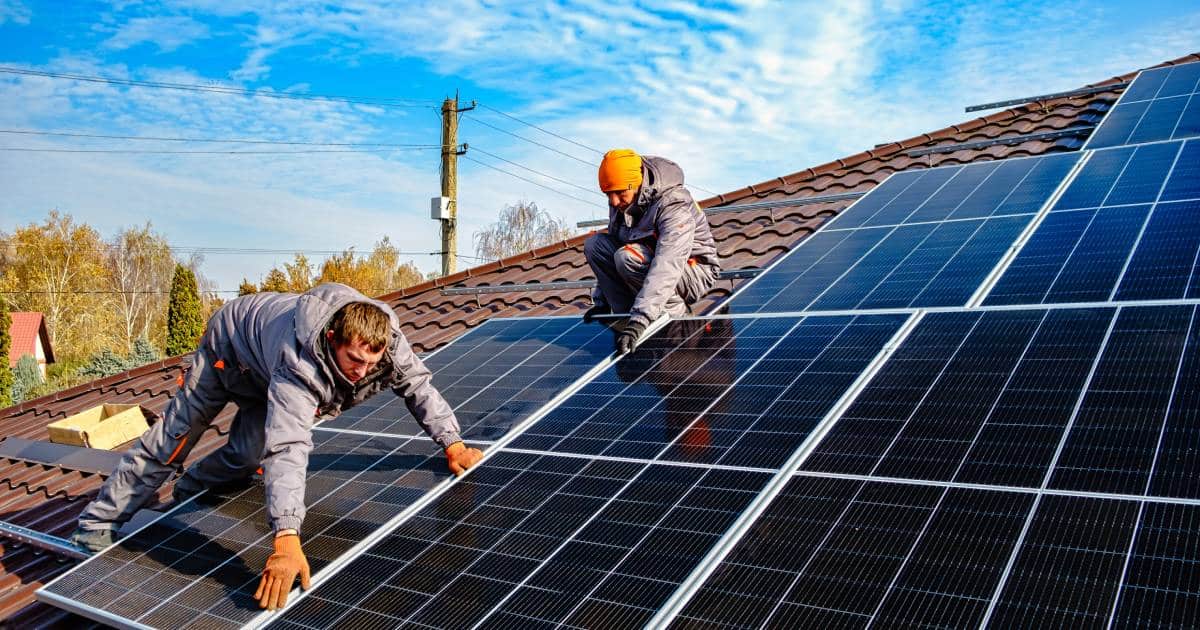 Des installateurs de panneaux solaires sur un toit