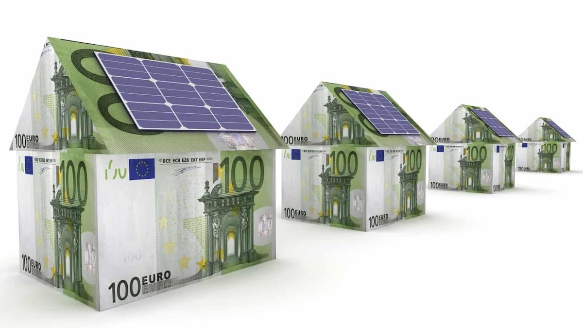 Maison emballé avec des billets de 100 euro et des panneaux solaires