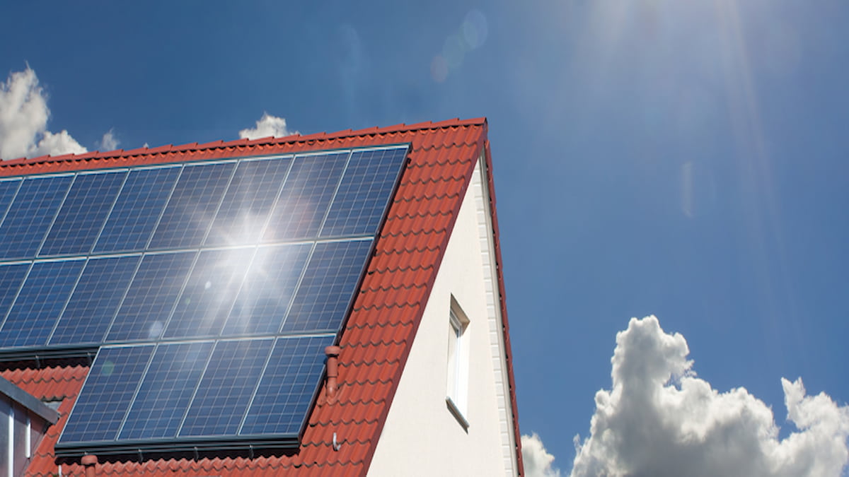 Une maison avec un toit en tuiles rouges est équipée de panneaux solaires