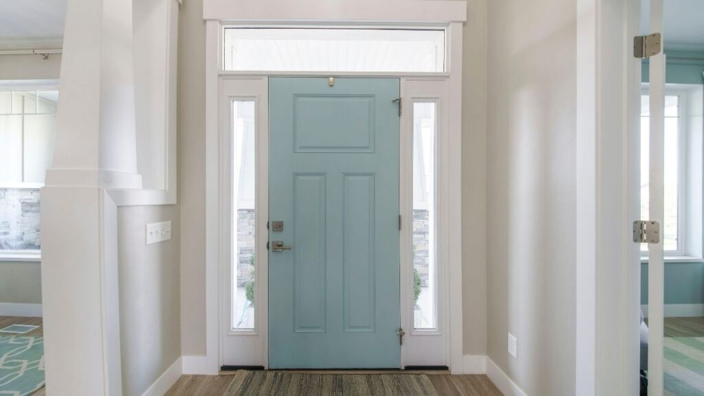 Hall d'entrée avec murs clairs et porte bleue
